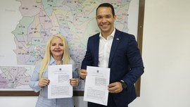 A imagem mostra a presidente do TRE-MT e o secretário controlador-geral do Estado, em ambiente i...