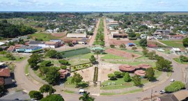 Esta imagem apresenta uma vista aérea de uma pacata cidade rural, destacando uma praça central c...