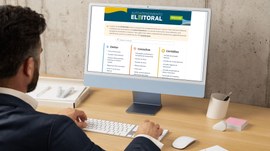 A imagem mostra um homem sentado à mesa, utilizando um computador que exibe a nova página de aut...