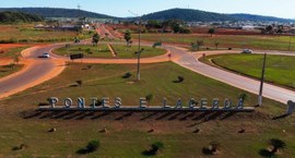 A imagem apresenta uma vista parcial aérea da entrada da cidade de Pontes e Lacerda, destacando ...