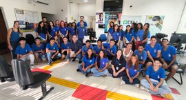 Um grupo de aproximadamente 30 jovens estudantes, acompanhados de adultos, posa para uma foto de...