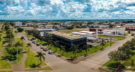 A imagem mostra uma vista aérea da área urbana de Sapezal, com destaque para um edifício moderno...