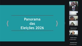 A imagem mostra uma reunião virtual realizada por videoconferência. Ao centro, está sendo compar...
