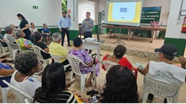 A imagem principal mostra um grupo de idosos reunido em um espaço comunitário, sentados em cadei...