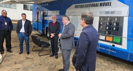 A imagem mostra um grupo de cinco homens reunidos em frente a uma unidade móvel da Justiça Eleit...