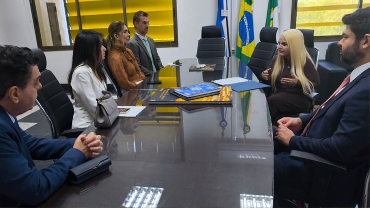 A imagem mostra a juíza Glenda Moreira Borges assinando o termo de posse como ouvidora eleitoral...