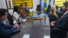 A imagem mostra a juíza Glenda Moreira Borges assinando o termo de posse como ouvidora eleitoral...