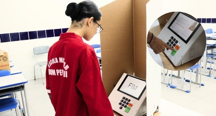 Escola Dom Pedro II realiza eleições para grêmio estudantil com urnas do TRE-MT #DescriçãodaImagem: A imagem mostra uma estudante de costas olhando para a urna eletrônica cuja ...