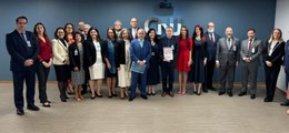 #PraTodosVerem: Imagem com parede na cor azul com escrito CNJ, com 21 participantes do Seminário...